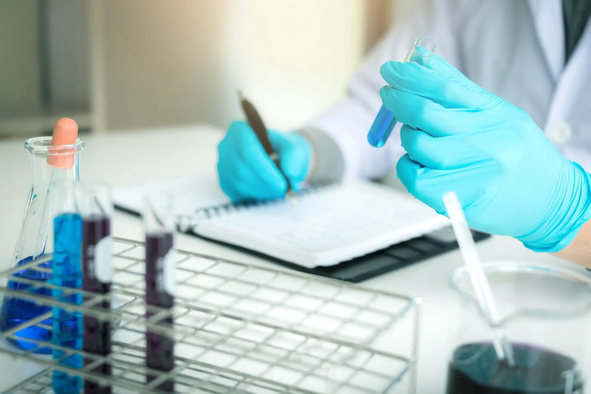 Scientist examining a water sample in a test tube at Oakwater Laboratories, Devon